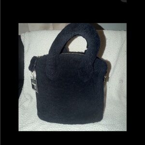 Louis Vuitton Locking Pulsion bag crafted from black shearling, gold hardware.